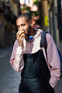 黑人年轻人在街上吃苹果 走在街上黑色健康水果衣服休闲服男性城市成人毛衣胡须图片