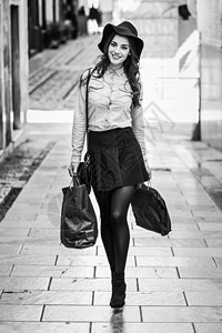妇女带着购物袋在街上行走帽子女性销售城市牛仔布迷你裙衬衫黑发礼物头发图片