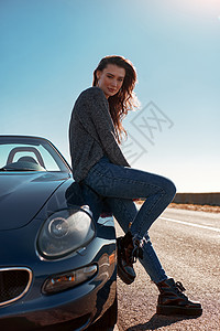 在路边阳光明媚的日子 站在无屋顶汽车露天外的年轻女子沙漠假期蓝色自由女性海滨车辆微笑乐趣太阳图片