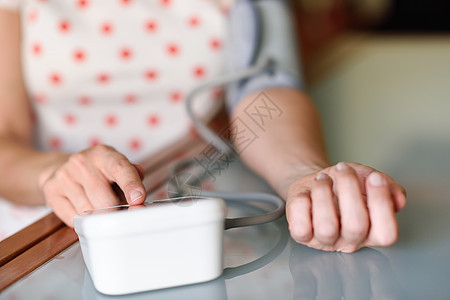 妇女在家里测量自己的血压 笑声心血管监视器成人女性病人高血压女士疾病测试手臂图片