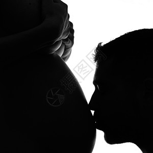 男人亲吻他怀孕妻子的肚子图片