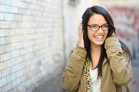 城市背景有吸引力的年轻女孩学生幸福力量乐趣青少年女性音乐街道成人耳机图片