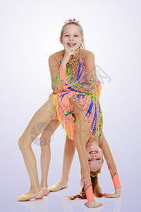 两个女体操运动员在修桥演员孩子们紫色训练地面姿势运动戏服童年女孩图片