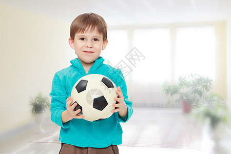 小男孩拿着足球球大学学校训练木板课堂游戏微笑房间孩子玩家图片