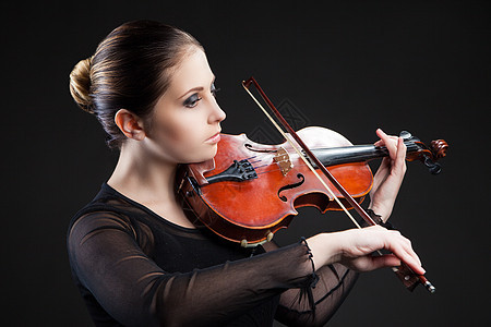 美丽的年轻女士 在黑色上拉小提琴学校成人乐队仪器交响乐艺术家艺术协奏曲旋律乐器图片