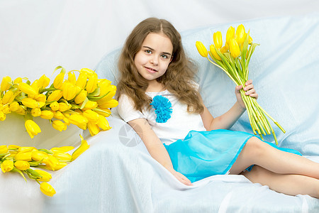 金发美丽的女学生 黄色郁金香的郁金香快乐展示花朵童年母亲礼物白色裙子女性妈妈们图片
