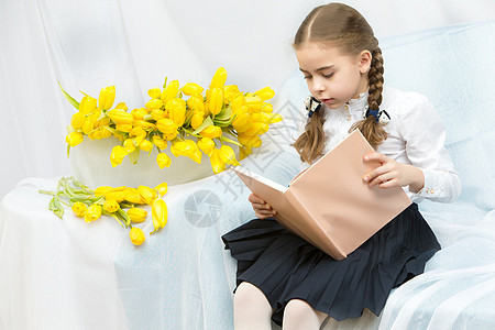 一位有黄色郁金香的勤奋女学生坐在T微笑妈妈们童年礼物母亲花束女性裙子孩子白色图片
