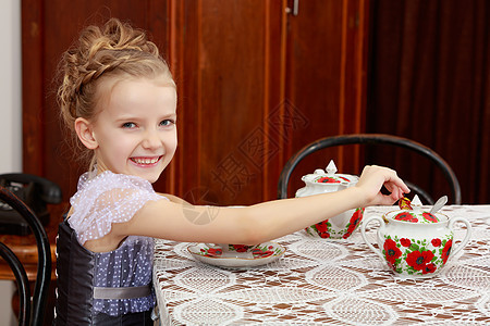可爱的小女孩在旧桌边喝茶食物女性裙子微笑孩子们青年幸福坡度婴儿孩子图片