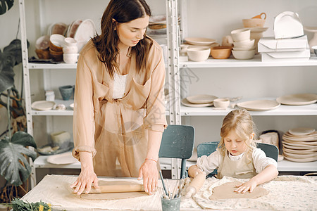 母亲和小女孩一起塑造粘土的肖像爱好黏土职业艺术孩子家庭学校陶瓷桌子童年图片