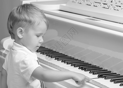 弹钢琴的小男孩音乐家乐趣幼儿园男生学校孩子水平音乐黑色床单背景图片