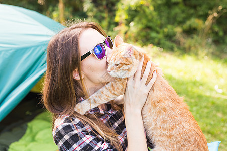 人 夏季旅游和自然概念     在帐篷附近有猫的年轻妇女背包假期音乐家闲暇宠物野营女孩远足者皮带喜悦图片