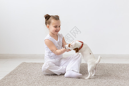 狗 儿童和宠物概念     与可爱小狗坐在地上的小女孩快乐压痛动物工作室幸福女孩友谊乐趣朋友猎犬图片
