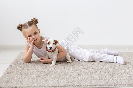 童年 宠物和狗概念     小女孩与小狗在地板上摆布说谎乐趣犬类袜子地面猎犬黑发工作室幸福友谊图片