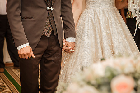 新郎穿着棕色西装 紧紧握着新娘的手家庭妻子男人庆典男性夫妻裙子浪漫婚姻戒指图片