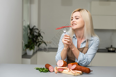 有吸引力的年轻女子 在叉子上拿着香肠美食猪肉食物油炸冒充燃烧文化小路头发剪裁图片