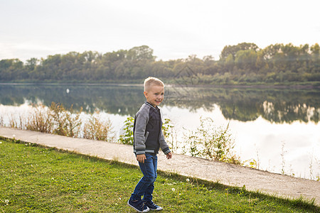 儿童与童年概念     在河边行走的年轻男孩公园假期家庭婴儿幸福池塘石头森林小路乐趣图片