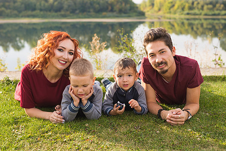 儿童 父母亲和自然概念     生活在草地上的大家庭喜悦成人公园栗色男性母亲头发孩子们快乐衬衫图片