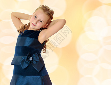 穿蓝裙子的漂亮小女孩  是的微笑乐趣头发孩子冒充金子黄色棕色童年时尚图片