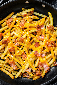 金炸薯条 煎鸡尾奶酪 和培根在锅里 黑色背景 顶级视图图片