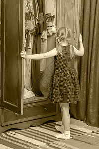 小女孩看衣柜里的样子购物者女性收藏店铺衣架房间婴儿童年裙子顾客图片