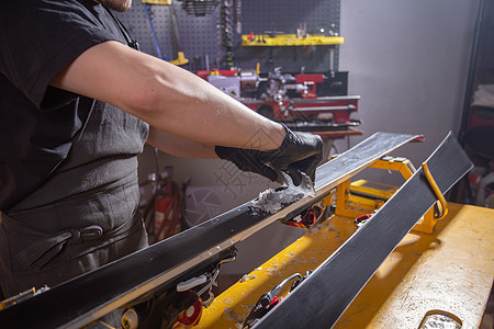 工作和维修概念     一个人的手用擦石蜡来修理滑雪尾巴工匠温度划痕石蜡木板斜角框架木头宏观图片