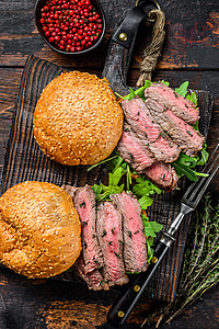 带牛肉牛排切片 阿鲁古拉和菠菜的汉堡 黑木背景图片