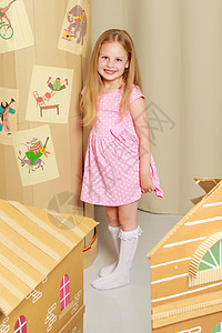 一个小女孩在纸板屋里玩游戏游戏建造微笑娃娃玩具喜悦童年木头女孩房子图片