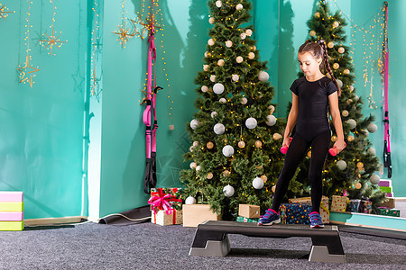 圣诞快乐 新年快乐 小女孩在家里在圣诞节室内锻炼 小黑发女模特有练习夫妻电脑生活方式快乐乐趣肌肉运动青年家庭互联网图片