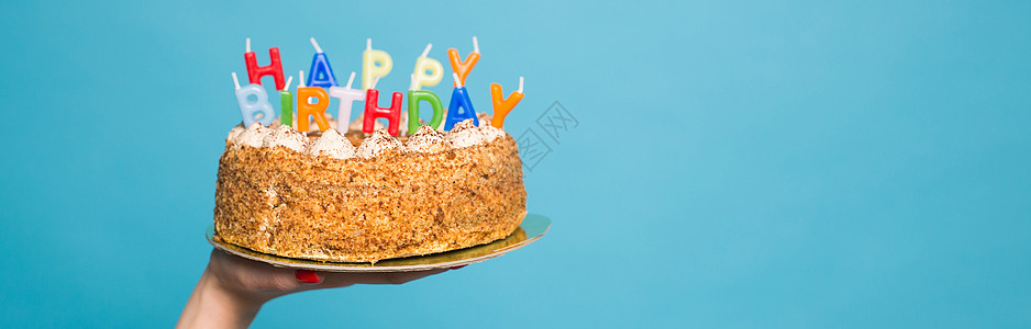 生日蛋糕海报手握生日蛋糕 蜡烛和在蓝背景上登记生日 复制空间 Copy Space情绪潮人纪念日喜悦创造力节日庆典蓝色娱乐问候语背景