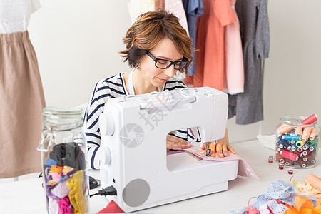 服装设计师 女裁缝 人物概念  服装设计师在她的工作室工作商务成人桌子纺织品缝纫服务女装人士裁缝手工图片