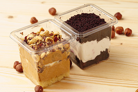 木制桌上塑料盒中的奶油甜点咖啡店杯子食物桌子可可小吃蛋糕甜品盒罐子木桌图片