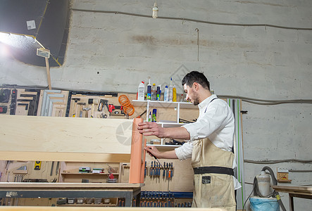 小型公司 家具和工人概念  在家具厂工作的英俊年轻人木材作坊职业工匠男人生产工具技术工艺工作服图片