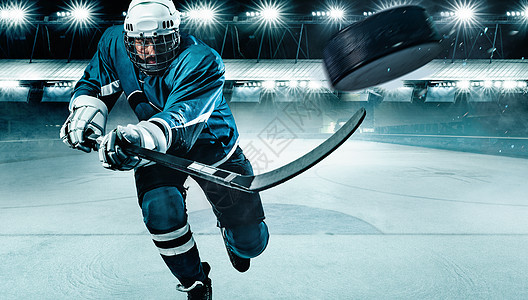 戴头盔的冰球运动员和在体育场用棍子戴手套的拳击手男性守门员滑冰竞赛曲棍球运动溜冰场男人竞技场面具图片