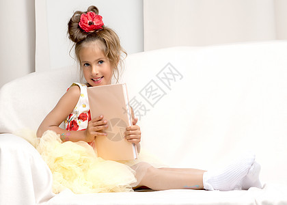 一个小女孩坐在沙发上 读着一本书女儿女性女孩教育知识快乐阅读故事书幸福喜悦图片