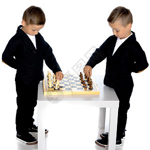 两个小男孩下象棋桌子孩子们沉思智力爱好孩子房间男性青年游戏图片