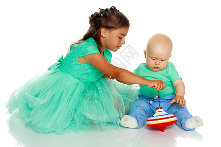 一个小女孩 带着弟弟玩耍卡通片玩具金字塔风车白色男生旋转游戏女孩婴儿图片