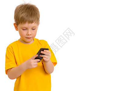 一个小男孩在手机上进行交流触摸屏阅读微笑工具闲暇幸福电脑电话智能笔记本图片
