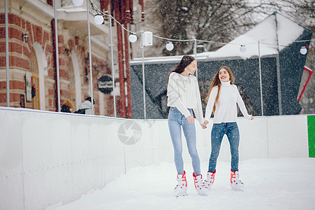 穿白色毛衣的可爱美女 在冬天的城市里竞技场快乐化妆品滑冰衣服女朋友享受牛仔裤季节闲暇图片
