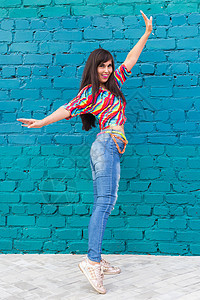 街头舞蹈 自由式和爵士乐怪人概念     美丽的女孩在蓝砖墙上跳嘻哈舞图片