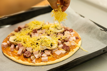 小女孩在家做比萨饼面粉面团女性糕点童年食物草药烹饪蔬菜派对图片