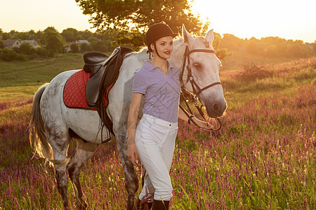 夜间日落时 骑马的年轻女孩抚摸和拥抱白马青少年感情编织农村宠物马术爱好骑师运动农业图片