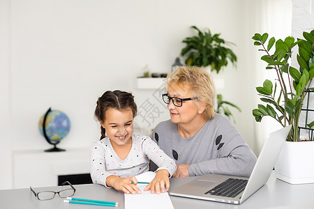 帮助她可爱的外孙女做家庭作业 为她服务的外婆提供帮助卡通片奶奶女士婴儿教育黑发学习药片祖母电脑图片