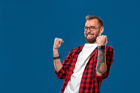 情感和人的概念 穿中衣衬衫的有胡子的年轻男子 嬉皮士风格 胜者展示技术胡须蓝色成人时尚快乐红色工作室手势图片
