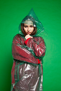 身穿雨衣的妇女站在绿色背景工作室姿势安全服饰女士隐藏个性外貌塑料材料女性图片