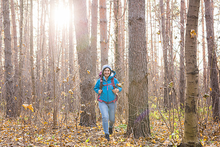 冒险 旅行 旅游 远足和人的概念  在森林深处行走的迷人微笑旅游女性蓝色季节背包行动夹克远足者娱乐女士天气踪迹图片