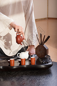 年轻男子举行中华茶礼仪式专注杯子和服房间传统黑发古董制品茶壶图片