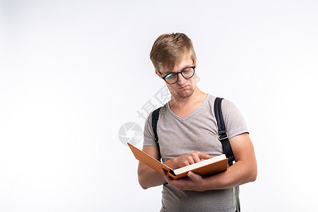 教育 大学 人的概念  戴眼镜的男学生打开一本书 在白色背景中微笑 有复制空间喜悦金发青年青少年极客衬衫背包推杆学习男人图片