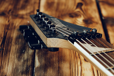 配有深底背景调音器的吉他头牌指板坚果木头细绳乐器钉头音栓音乐图片