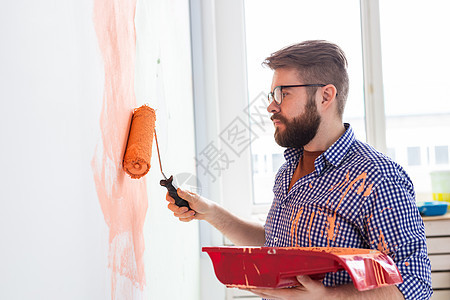 在公寓里修理 男人用油漆刷墙工具承包商装潢滚筒房间房子工作服务装修刷子图片