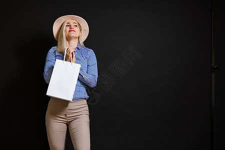 拿着袋子的购物妇女 隔绝在黑背景 黑色星期五概念成人顾客魅力购物者裙子时尚闲暇购物中心零售女孩图片